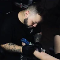 a man is getting a tattoo on his arm